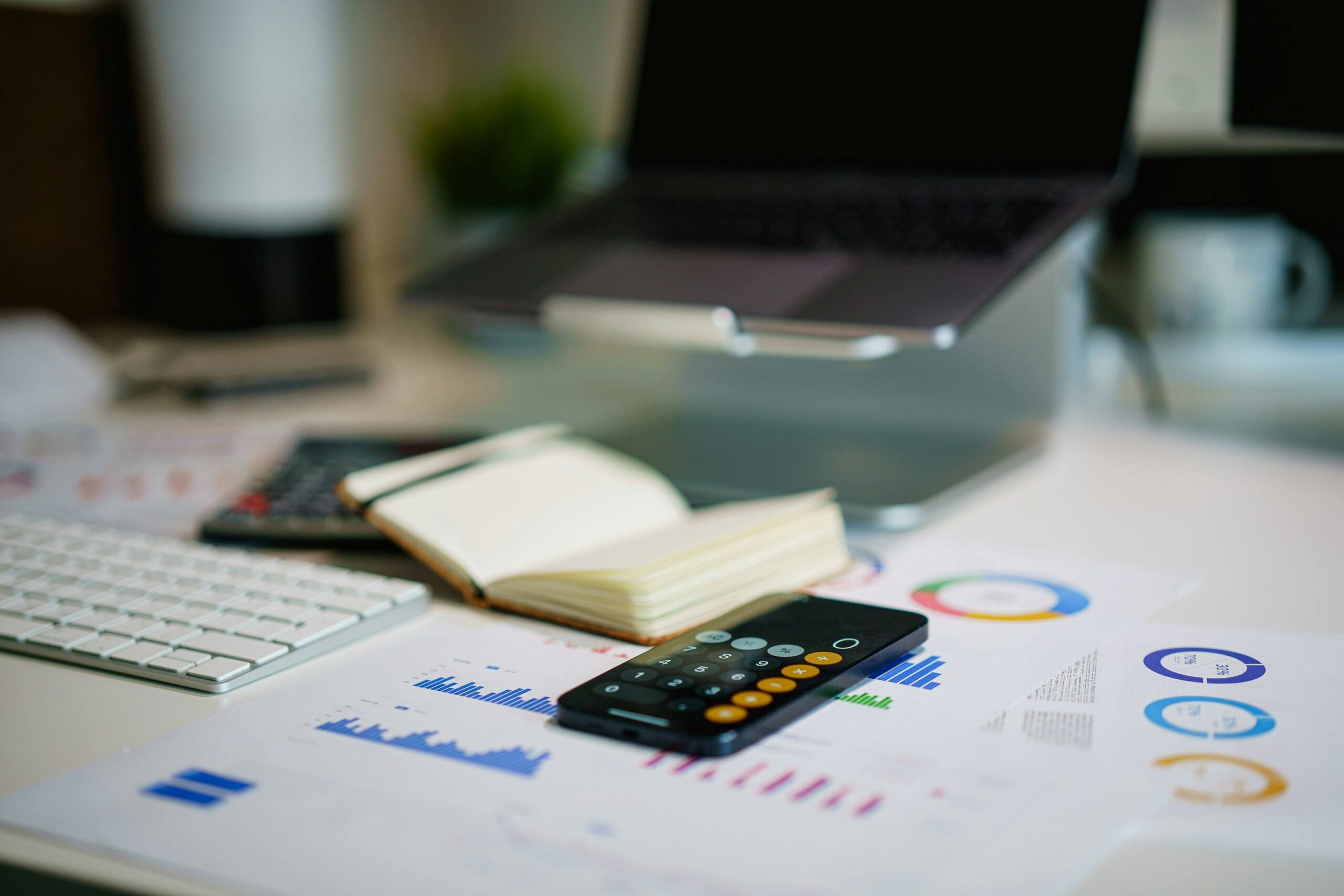 Author budgeting how much it costs to self publish a book with a calculator, notebook and coins